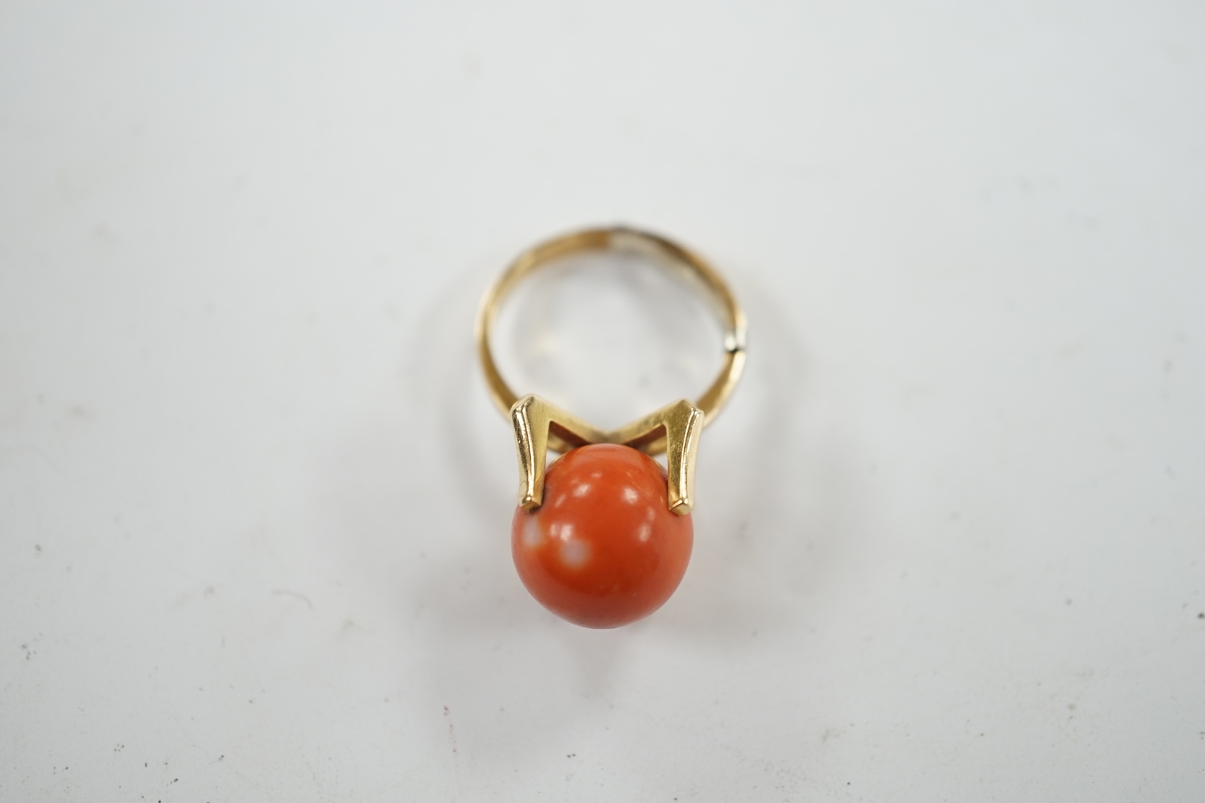 A continental yellow metal and single stone coral bead set dress ring, size O, gross weight 7.7 grams. Condition - fair